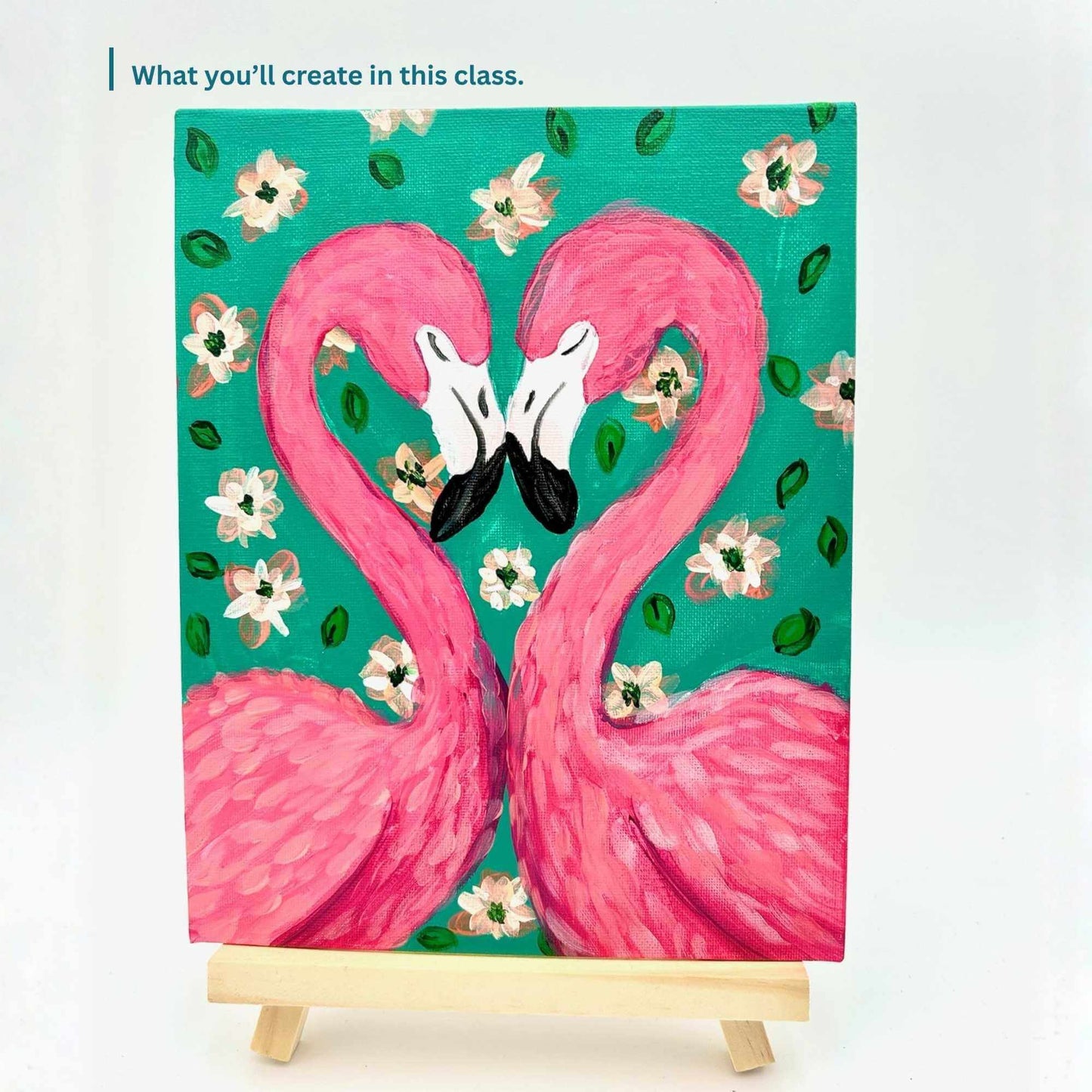 Painting of two pink flamingos on a teal background with flowers, on a small easel.